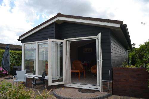 a small black shed with a glass door at Wuivend Riet gelegen op Resort Venetie in Giethoorn