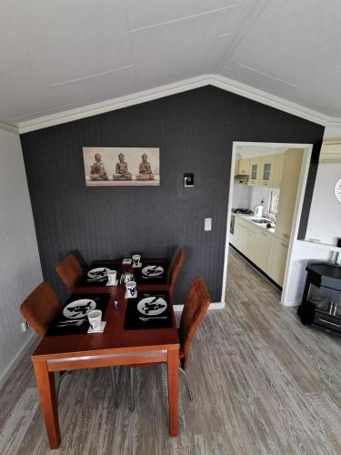 a dining room with a table and chairs and a kitchen at Wuivend Riet gelegen op Resort Venetie in Giethoorn