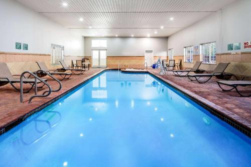 uma grande piscina com cadeiras num quarto em La Quinta by Wyndham Alamo-McAllen East em Alamo