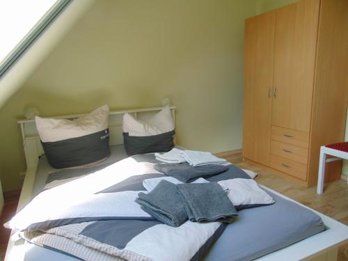Bett mit Kleidung auf einem Zimmer in der Unterkunft Ferienwohnung auf Rügen in Maltzien in Losentitz