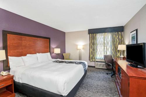 a hotel room with a bed and a desk and a television at La Quinta by Wyndham Knoxville North I-75 in Knoxville