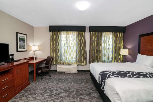 a hotel room with a bed and a desk at La Quinta by Wyndham Knoxville North I-75 in Knoxville