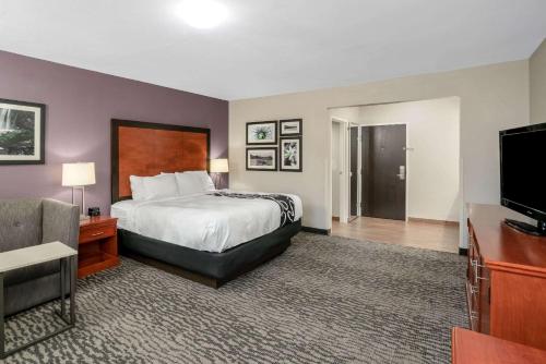 a hotel room with a bed and a flat screen tv at La Quinta by Wyndham Knoxville North I-75 in Knoxville