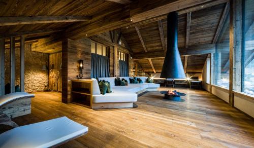 una sala de estar con muebles blancos y techos de madera. en Hotel Vernel en Santa Cristina in Val Gardena