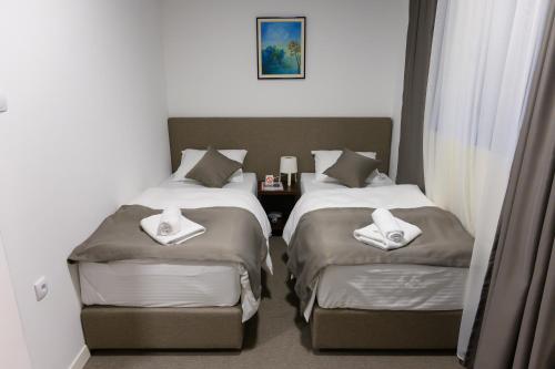 a hotel room with two beds with towels on them at Jezero Kudrec in Smederevska Palanka