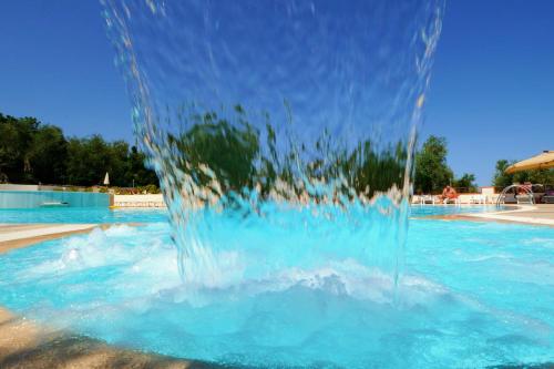 a water fountain in the middle of a swimming pool at Zagare Residence in Rodi Garganico