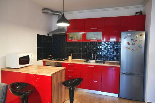 a kitchen with red cabinets and a stainless steel refrigerator at Apartment Grbin in Pula