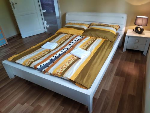 a bed in a bedroom with yellow and brown sheets at Dom nad jeziorem in Giżycko