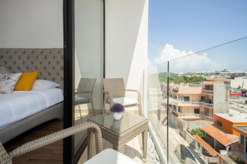 Un dormitorio con una cama y una mesa en el balcón. en Edificio Vanessa 24 studios, en Playa del Carmen