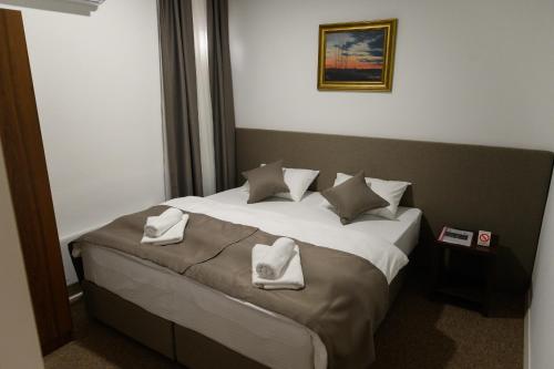 a bedroom with a bed with white towels on it at Jezero Kudrec in Smederevska Palanka