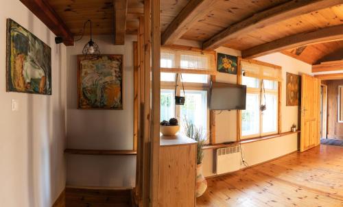 a living room with wooden ceilings and a large window at Domek Malarza Matarnia in Gdańsk