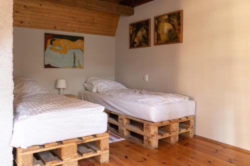 2 łóżka pojedyncze w pokoju z drewnianą podłogą w obiekcie Domek Malarza Matarnia w Gdańsku