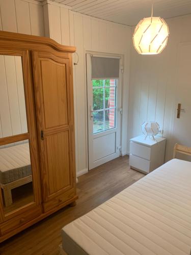 ein Schlafzimmer mit einem Bett, einem Schrank und einem Fenster in der Unterkunft Ferienhaus Anker an der Nordsee in Dornum