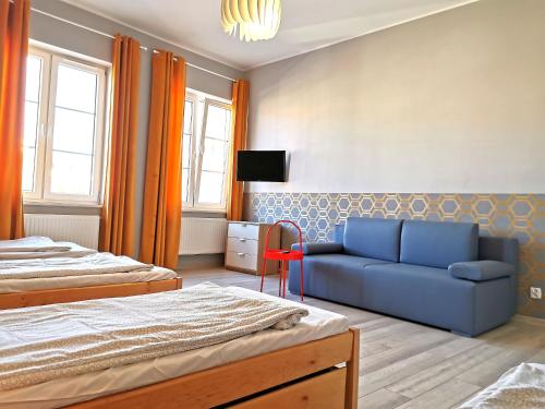 グダニスクにあるApartament ul.Stągiewnaのベッドルーム1室(ベッド2台、青いソファ付)