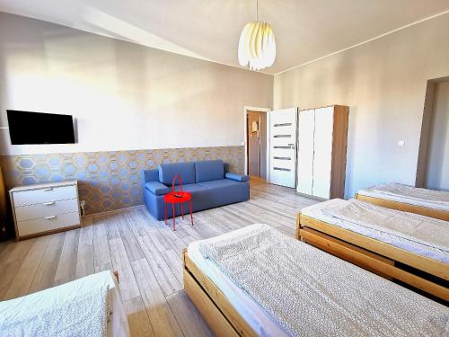 グダニスクにあるApartament ul.Stągiewnaのベッド2台と青いソファが備わる客室です。