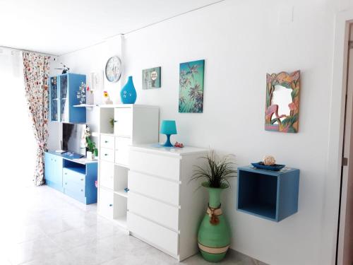 Habitación con armarios blancos y muebles azules. en Apartamento Tropicana en Denia