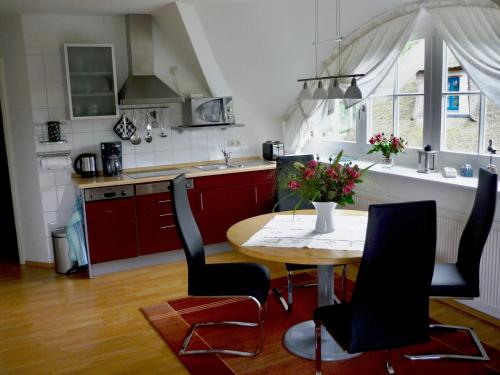 eine Küche mit einem Tisch und Stühlen in der Unterkunft Ferienhaus Mine Sehnsucht in Dierhagen
