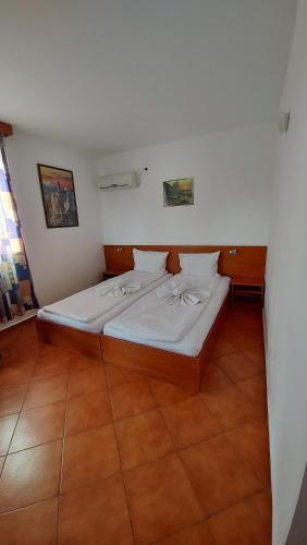1 dormitorio con 1 cama grande con sábanas blancas en Hotel Bon Relax, en Ravadinovo