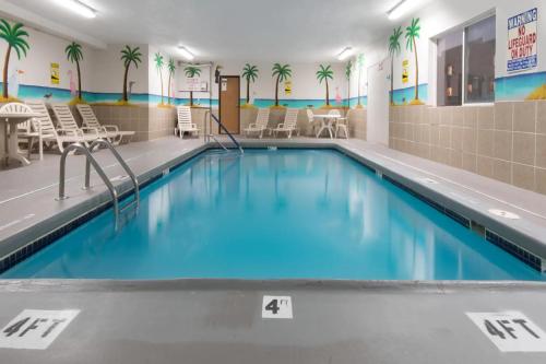 a swimming pool with blue water in a building at Days Inn by Wyndham Kansas City International Airport in Kansas City