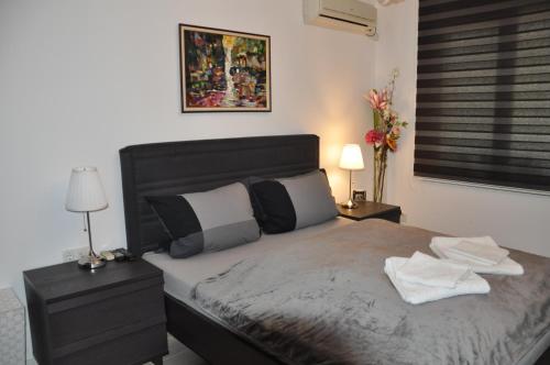 een slaapkamer met een bed, 2 lampen en een raam bij City apartment Varna in Varna