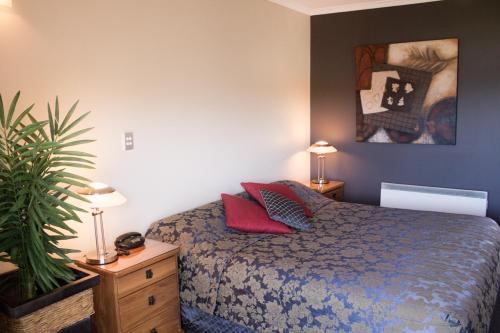 a bedroom with a bed and a painting on the wall at Beachcomber Inn Picton in Picton