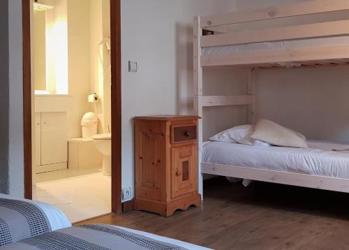 a bedroom with two bunk beds and a bathroom at Savoy Hotel & Restaurant in Saint-Michel-de-Maurienne
