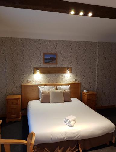 a bedroom with a large white bed with lights on it at Savoy Hotel & Restaurant in Saint-Michel-de-Maurienne