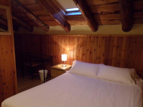 a bedroom with a bed with a lamp on a table at Hotel Roc de St Miquel & Apartment in Soldeu
