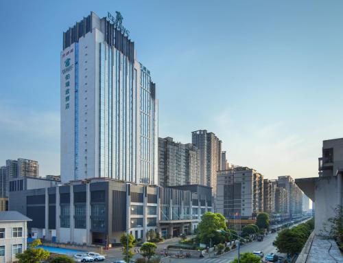 a city with tall buildings and a street with cars at Perenc Hotel in Anshun