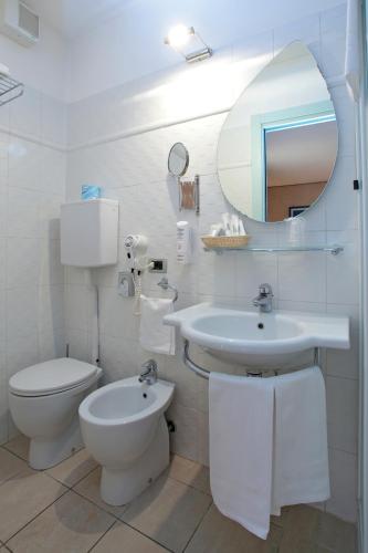a white bathroom with a toilet and a sink at Hotel Centrale in Bologna