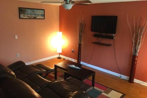 a living room with a couch and a flat screen tv at Cozy retreat in sunny Florida in Sarasota