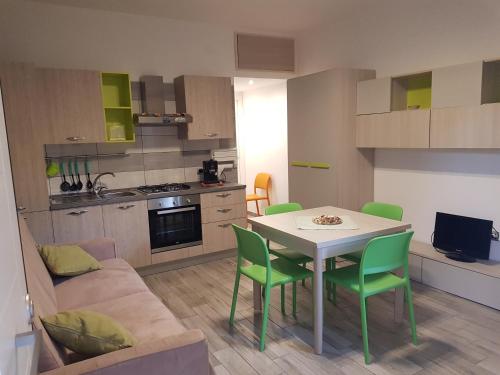 卡塔尼亞的住宿－Sole e Luna，厨房以及带桌子和绿色椅子的客厅。