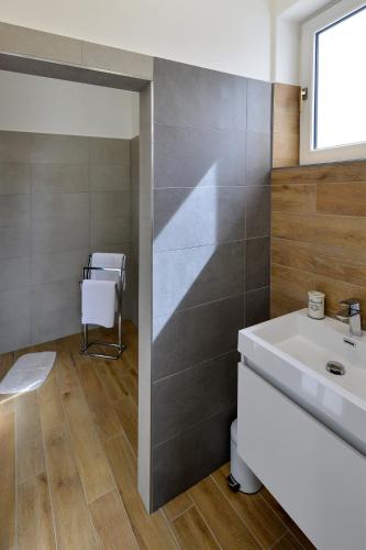 a bathroom with a white sink and a mirror at Soho apartment in Písek