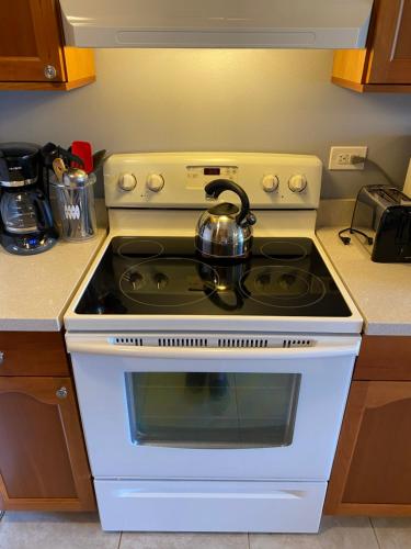 a white stove top oven with a tea kettle on it at Perfect for families and couples - Maui Sunset A-203 in Kihei