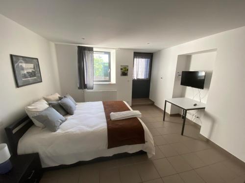 a bedroom with a large bed and a television at Auberge de Thelis in Thélis-la-Combe