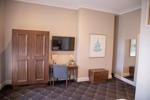 a room with a desk and a tv on the wall at Royal Hotel Randwick in Sydney