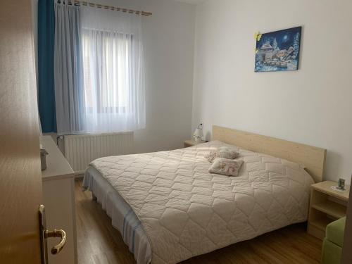 a bedroom with a white bed with a pillow on it at Apartmani Spomenka in Seline