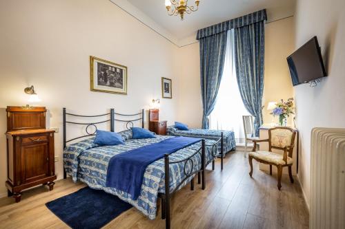 a bedroom with two beds with blue sheets and a tv at Casa di Barbano in Florence
