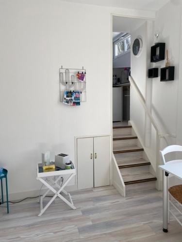 Cette chambre est dotée d'un escalier avec une table et un bureau. dans l'établissement Studio au cœur de Granville, à Granville