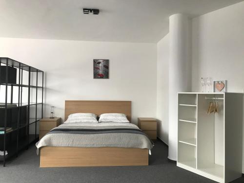 - une chambre avec un lit et un mur blanc dans l'établissement Maja Apartmán č 4, à Bešeňová