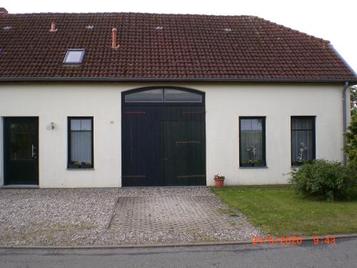 a white house with a black door at Ferienhaus Weitblick in Börgerende-Rethwisch