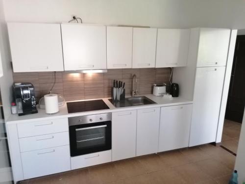 a white kitchen with white cabinets and a sink at Park Miedzywodzie in Międzywodzie