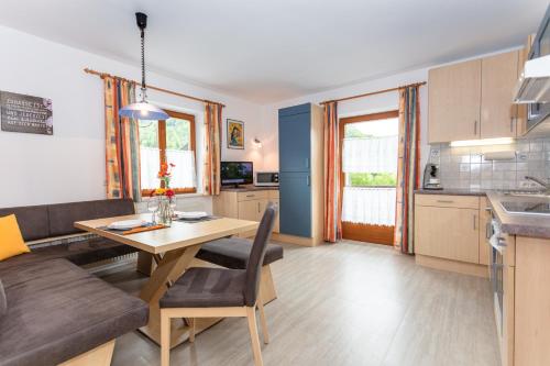 a kitchen and living room with a table and a couch at Bergheim Komfort Ferienwohnungen in Walchsee