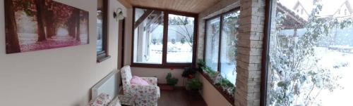 a hallway with two chairs and windows in a house at Penzión Thamasy in Spišské Tomášovce