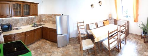 a kitchen with a stainless steel refrigerator and a table at Gasthaus Zehrermühle in Schönberg