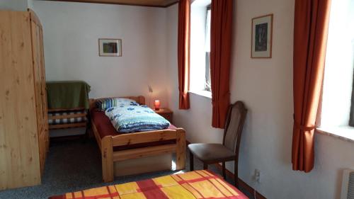 a small room with a bed and a chair in it at Gasthaus Zehrermühle in Schönberg