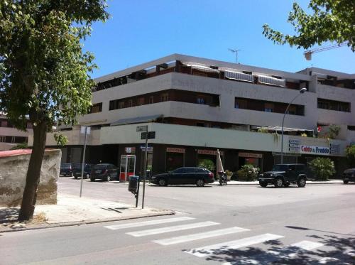 un grand bâtiment avec des voitures garées devant lui dans l'établissement Appartamento Signorile, à Alghero