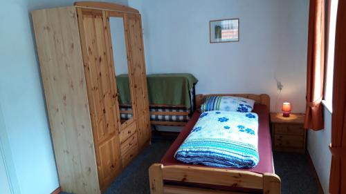 a small room with a bed and a wooden cabinet at Gasthaus Zehrermühle in Schönberg