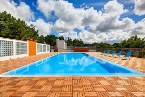 a large swimming pool with chairs on a patio at Apartament 11B Blue Marine Poddąbie in Poddąbie