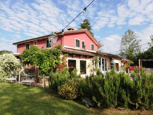 ein rosa Haus mit Garten im Hof in der Unterkunft Agricola casa cucina bottega in Cesena